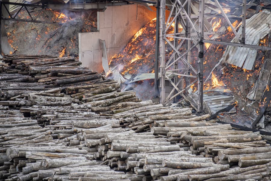 Feuerwehrleute loeschen einen Brand bei der Swiss Krono AG in Menznau, am Mittwoch, 9. August 2023. Auf dem Firmengelaende der Swiss Krono AG in Menznau ist am Mittwochmorgen in einer Holzlagerhalle ein Grossbrand ausgebrochen. Im Einsatz stehen 240 Feuerwehrleute. Verletzt wurde laut Polizei niemand. (KEYSTONE/Urs Flueeler)