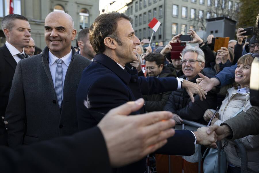epa10977085 French President Emmanuel Macron (C) and Switzerland President Alain Berset (L) greet the public, on the Federal square in front of the Federal Palace, the Swiss Parliament building, in Bern, Switzerland, 15 November 2023. French President Macron and his wife Brigitte are visiting Switzerland for a two day state visit. EPA/ANTHONY ANEX / POOL