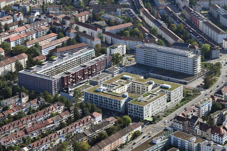 Luftbild des Westfeld-Projekts in Basel mit seiner markanten Solarpanel-Dachlandschaft.