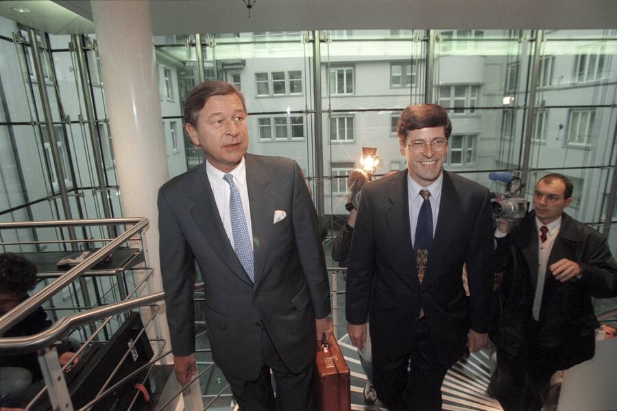 Der neue Praesident der United Bank of Switzerland (UBS), Marcel Ospel, links, und Matthias Cabiallavetta, Mitte, Vorsitzender des Verwaltungsrates der UBS, steigen am 8. Dezember 1997 gemeinsam die Treppe zum Presseraum hinauf, um die Fusion von Schweizerischer Bankgesellschaft (UBS) und Schweizerischem Bankverein (SBV) bekanntzugeben. Durch den Zusammenschluss entsteht das weltweit zweitgroesste Bankinstitut. Mit der Kamera folgt ihnen Urs Leuthard vom Schweizer Fernsehen. (KEYSTONE/Martin Ruetschi)