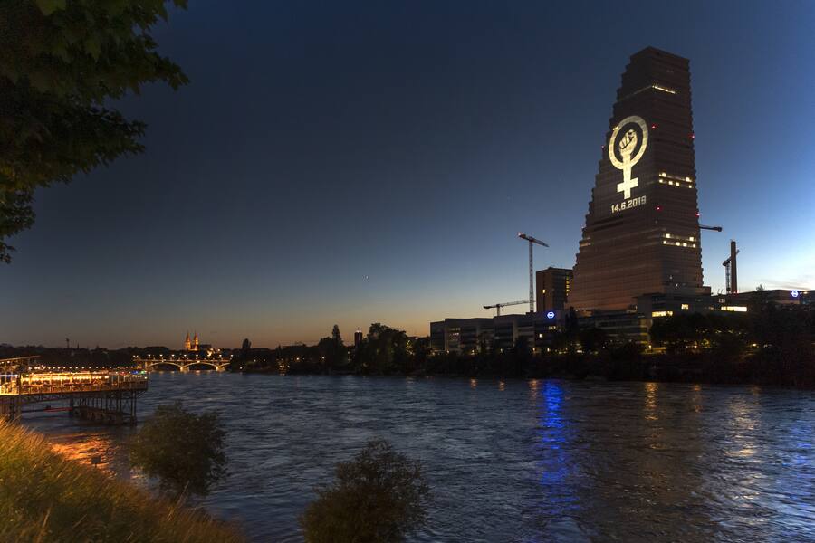 Das Logo des Frauenstreiks vom 14. Juni wird von der gegenueberliegenden Seite des Rheins auf den Roche-Turm projiziert in Basel, am Donnerstag, 13. Juni 2019. (KEYSTONE/Georgios Kefalas)
