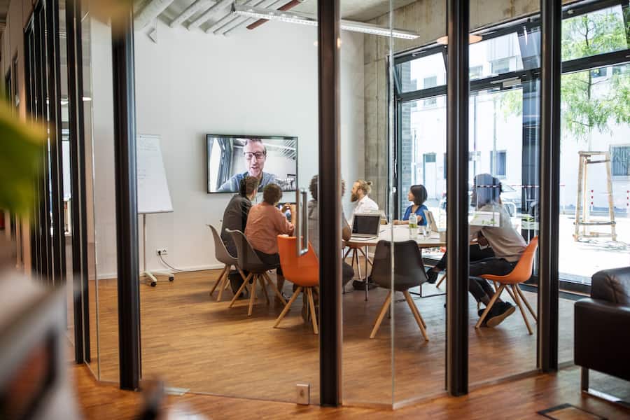 Multi-ethnic business people video conferencing in board room at office